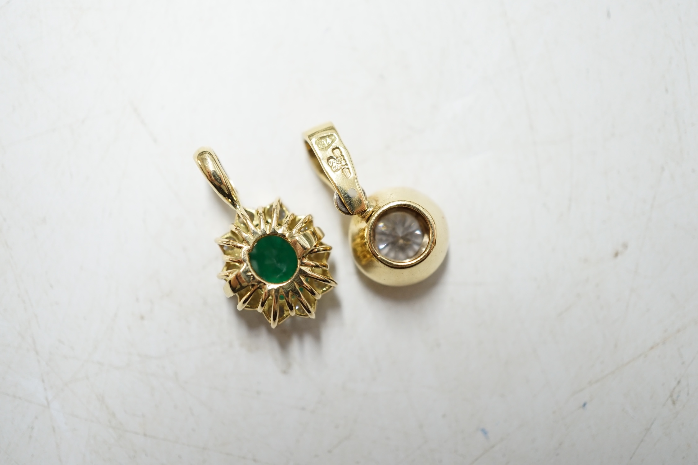 A modern 18ct gold and solitaire diamond set pendant and a similar unmarked yellow metal, emerald and diamond set oval pendant, gross weight 4,5 grams. Condition - fair to good